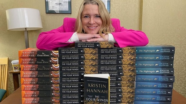 Kristin Hannah poses with a stack of her own boos