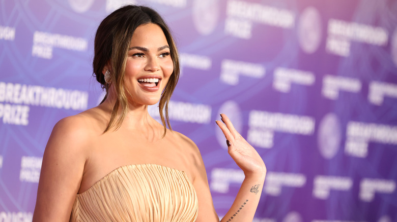 Chrissy Teigen waving on the red carpet