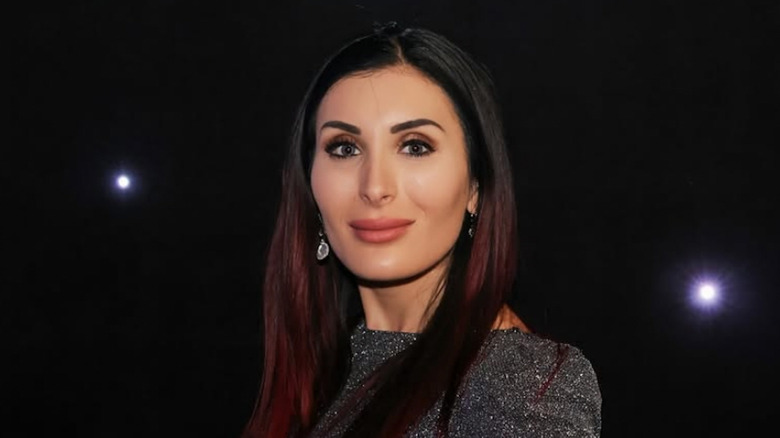 Laura Loomer in front of a black background with various dots of light
