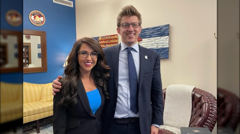 Representative Lauren Boebert with a voluminous blowout standing next to a man wearing a suit