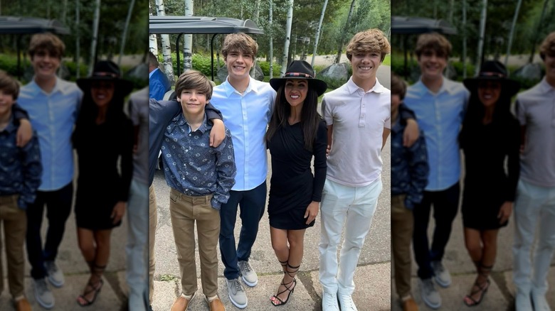 Lauren Boebert in a black dress and gladiator sandals standing with her kids