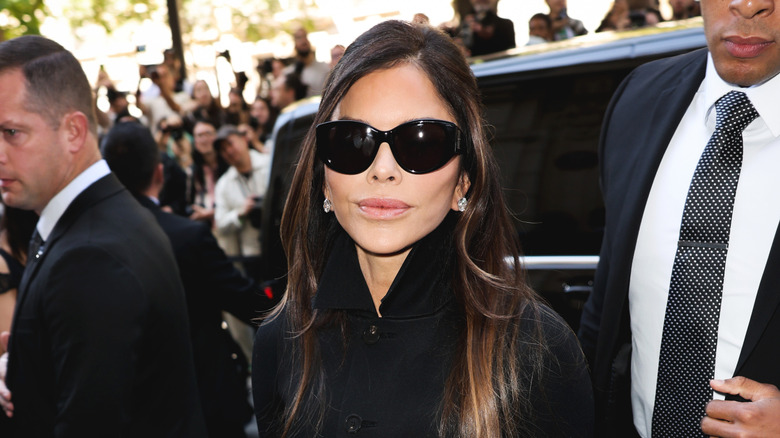 Lauren Sánchez Bezos exiting an SUV and looking into the camera while wearing oversized sunglasses