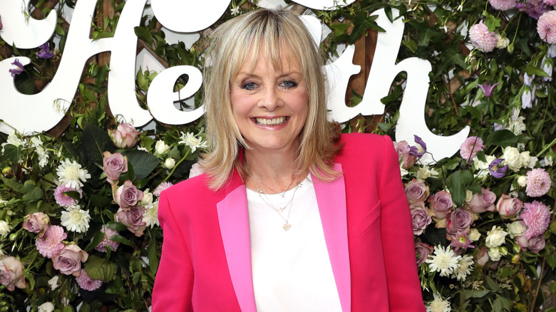 Twiggy at a Goop event smiling in a pink blazer and white T-shirt
