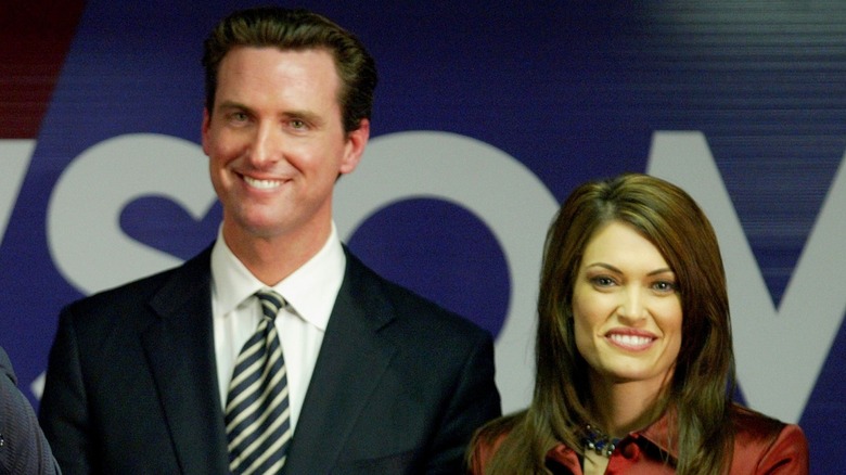 Gavin Newsom and Kimberly Guilfoyle, standing and smiling side by side at an event