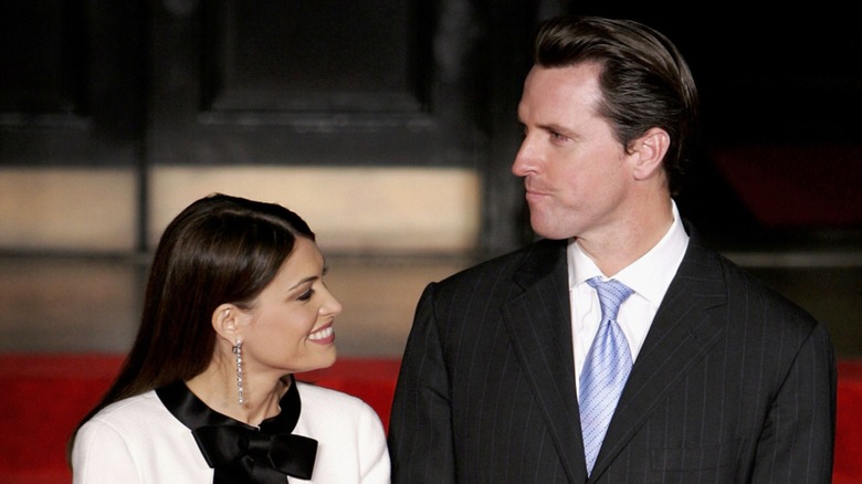 Kimberly Guilfoyle, smiling and looking past Gavin Newsom, who's beside her