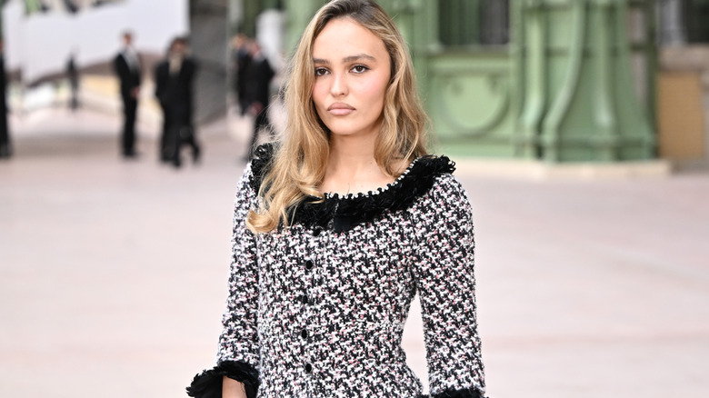 Lily Rose Depp in a black and white jacket looking at the cameras