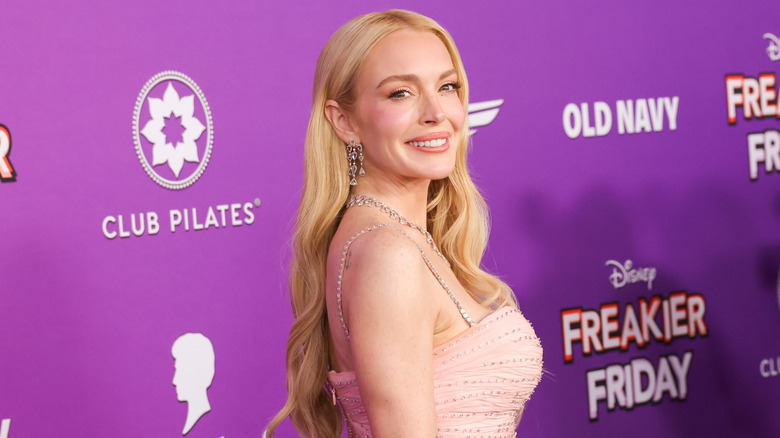 Lindsay Lohan with blonde hair and a pink dress on at an event