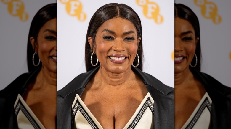Close-up of Angela Bassett, smiling while wearing a glossy, berry-toned lip color at a BFI event