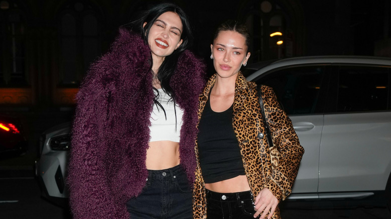 Amelia Hamlin smiles in a purple fur coat next to Delilah Hamlin in a leopard print coat