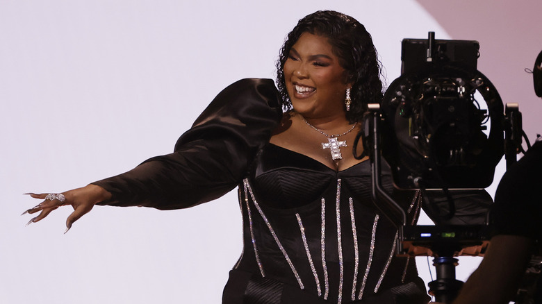 Lizzo wearing black dress, smiling