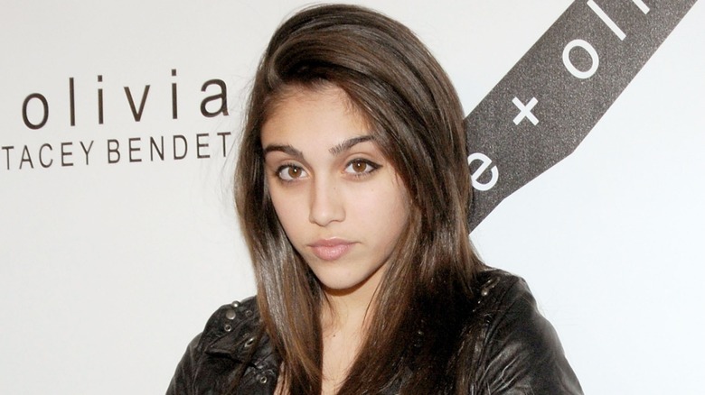 Lourdes Leon posing on the red carpet in 2010 in a leather-look jacket in front of a white background