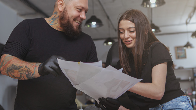 woman choosing tattoo design