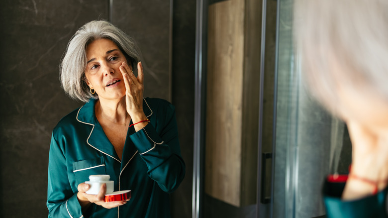 Older woman applying face cream
