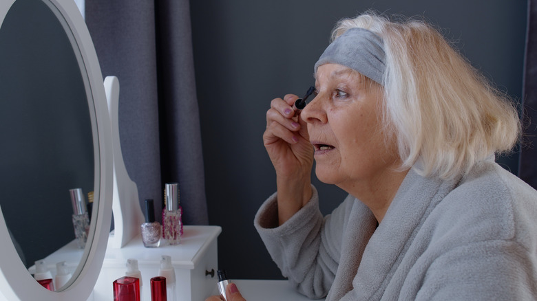 Older woman applying mascara