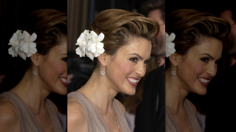Mariska Hargitay wearing a light beige dress and large white flower in her hair