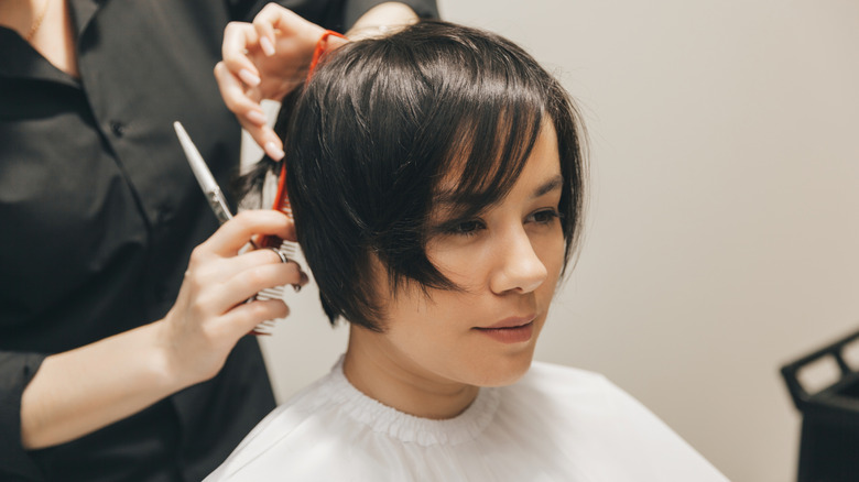 A woman getting her hair cut into a short pixie cut