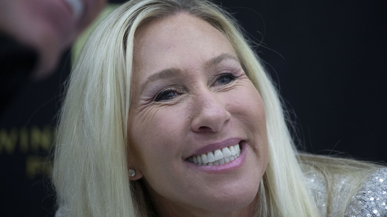 Marjorie Taylor Greene (R-GA) poses for a picture with a supporter at a book signing at Turning Point Action's "The People's Convention" on June 15, 2024 in Detroit, Michigan
