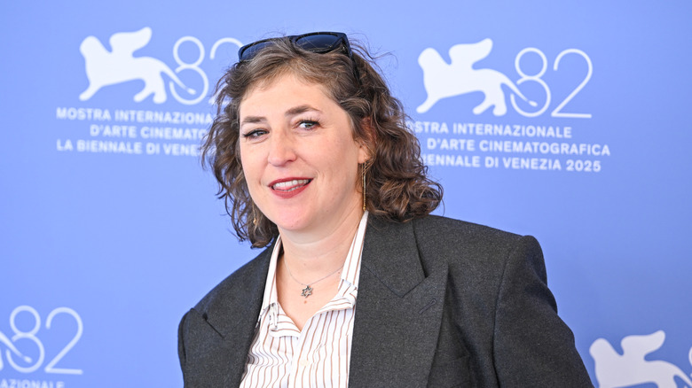 Mayim Bialik with her natural curls out wearing a black blazer