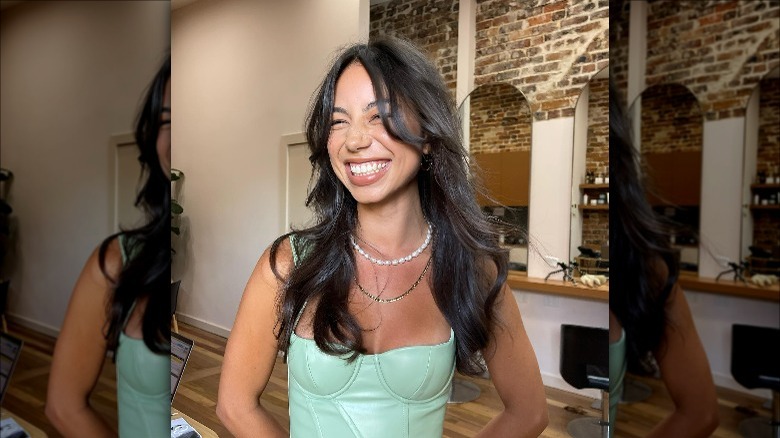 woman smiling in salon with butterfly cut