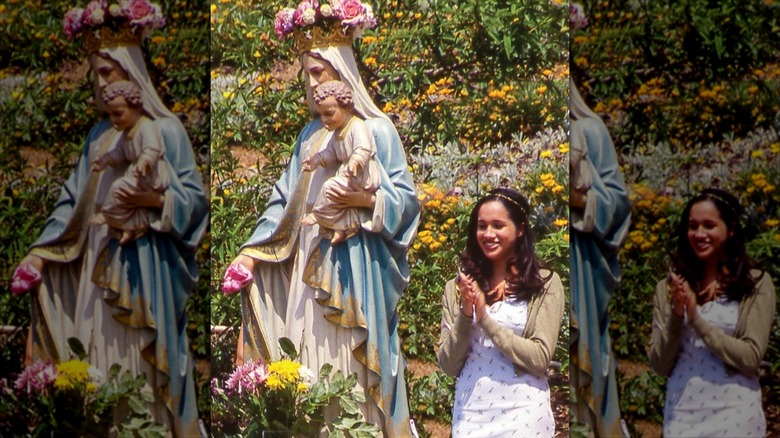 A young Meghan Markle standing next to a statue of the Virgin Mary