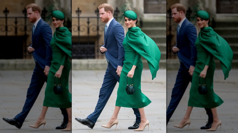 Meghan Markle walking hand in hand with Prince Harry in 2020 in a green dress with a cape and a fascinator