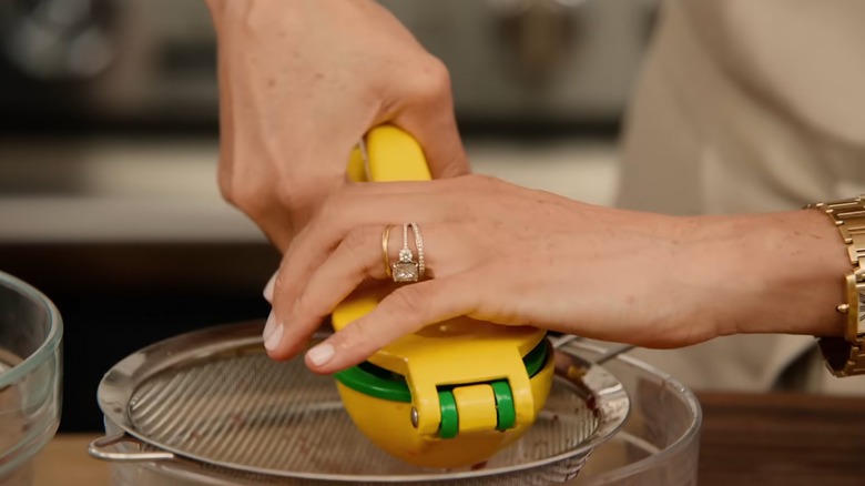 A close up shot of Meghan Markle using a lemon squeezer in her Netflix show