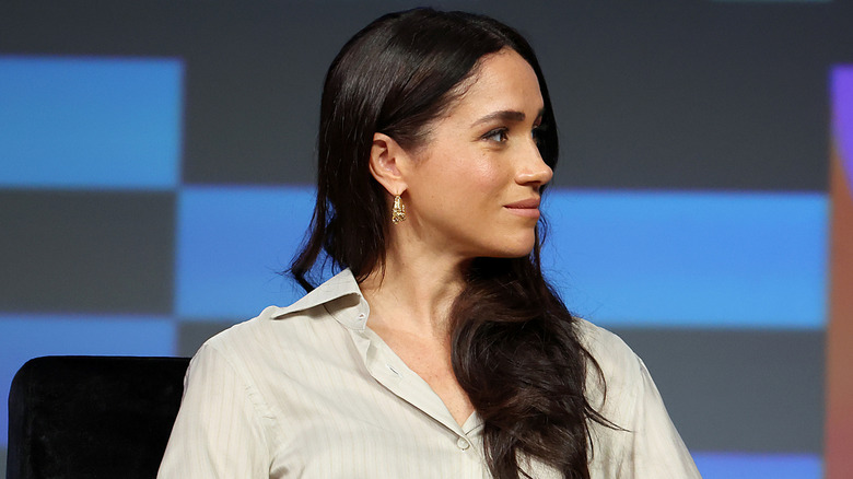 Meghan Markle smiling looking to the side