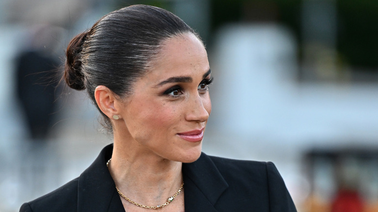 A close-up shot of Meghan Markle's face where her hair is slicked back into a bun