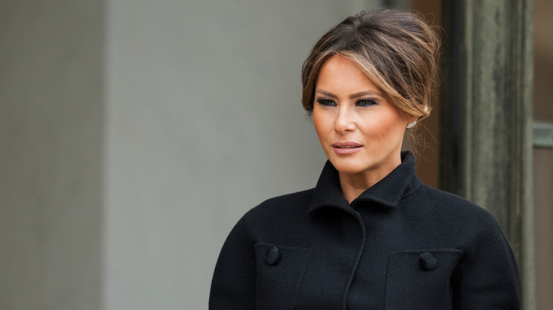 Melania Trump looking away from the camera in a black coat