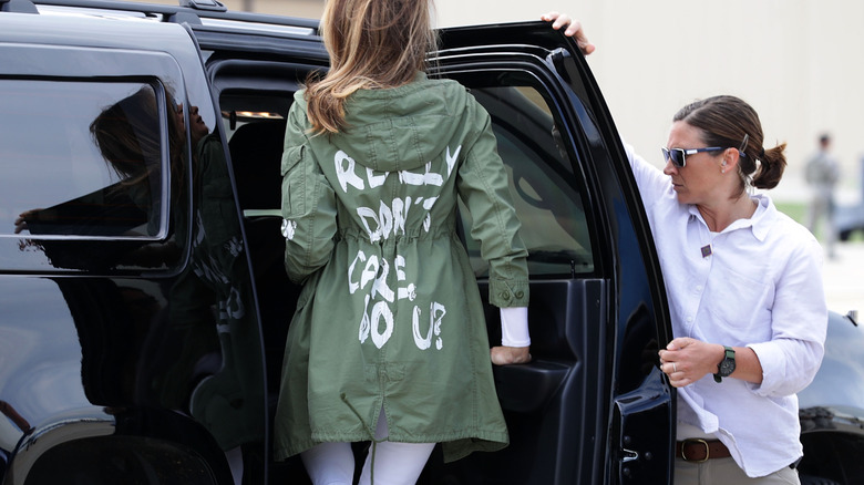 Melania Trump getting into a black SUV with her green jacket on