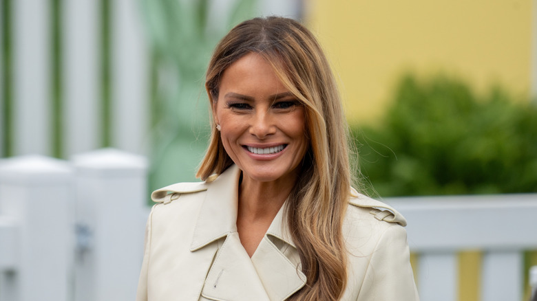 Melania Trump wearing a light-colored trench outdoors