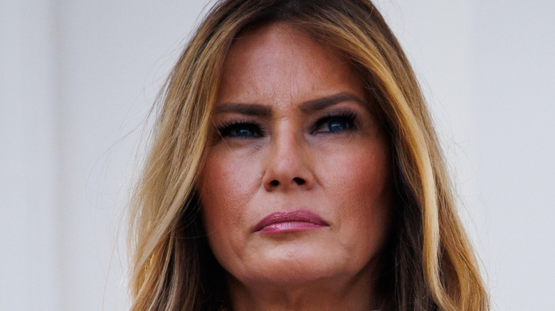 Melania Trump in a white shirt frowning