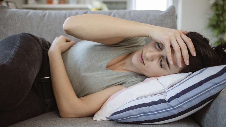 Woman in pain on couch
