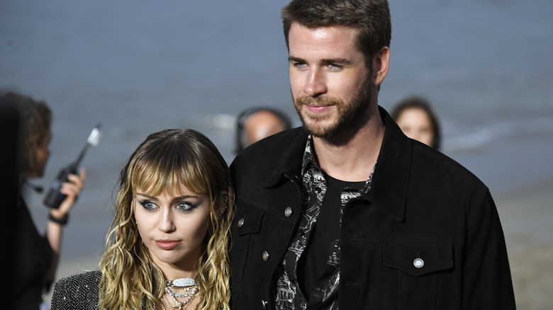 Miley Cyrus, Liam Hemsworth posing