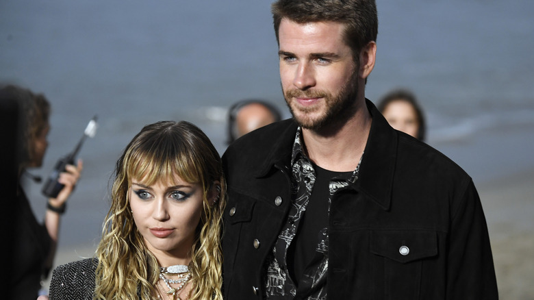 Miley Cyrus, Liam Hemsworth posing