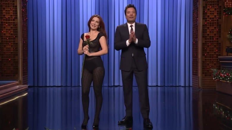 Millie Bobby Brown holding a rose and standing next to Jimmy Fallon on The Tonight Show