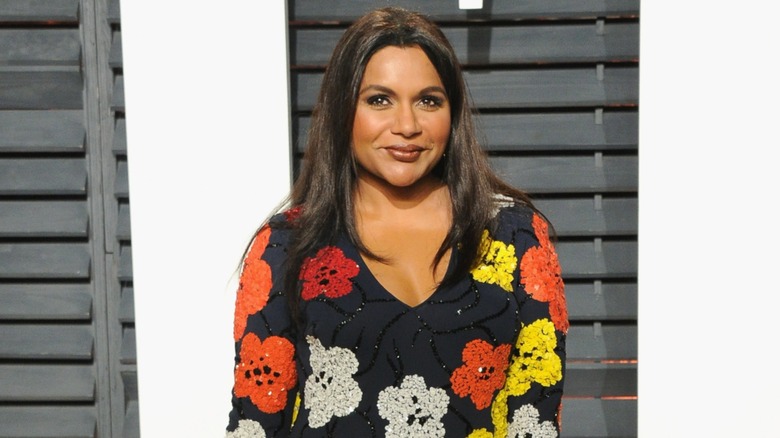 Mindy Kaling posing on the red carpet in 2017 in a floral dress