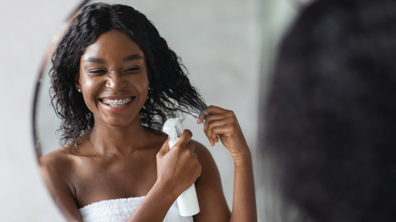Woman spraying hair
