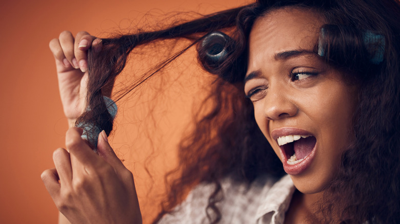 woman pulling hair out of rollers