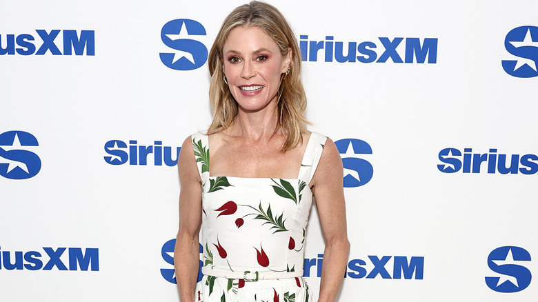 Julie Bowen in a white dress with red flowers at an event