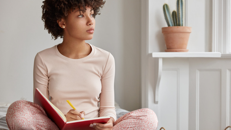woman journaling on bed