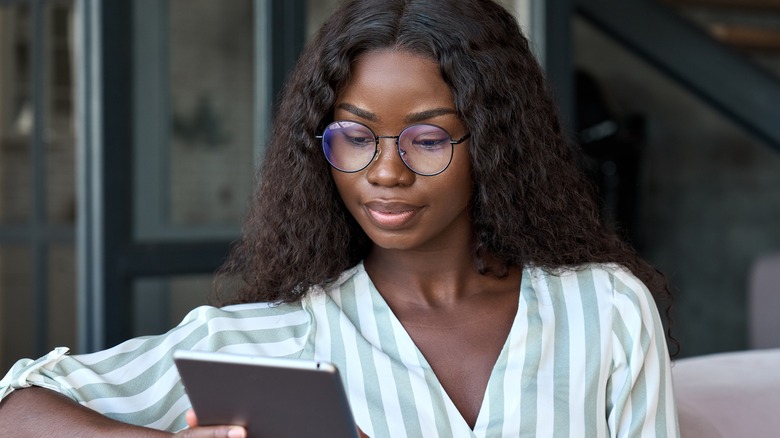 young woman looks at tablet