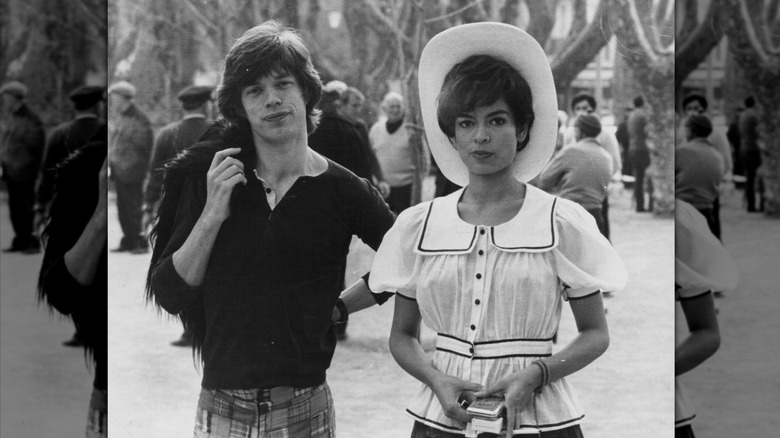 Bianca Jagger in a hat and a ruffle blouse and Mick Jagger in a black shirt