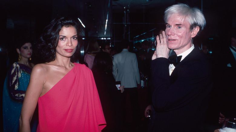 Bianca Jagger in red and Andy Warhol in a tux at an event