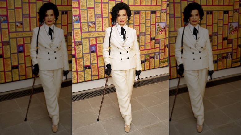 Bianca Jagger in a white suit with a black bow tie at an event