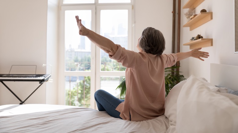 woman stretching in a cozy bedroom