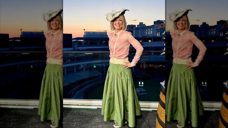 Dylan Dreyer posing in front of a racetrack in a green maxi skirt
