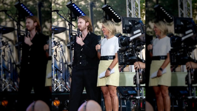 Dylan Dreyer onstage with a man and holding a microphone