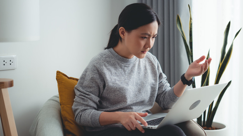 stressed woman uses laptop