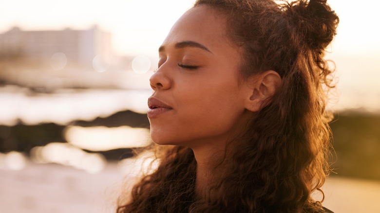 Woman outside with eyes closed